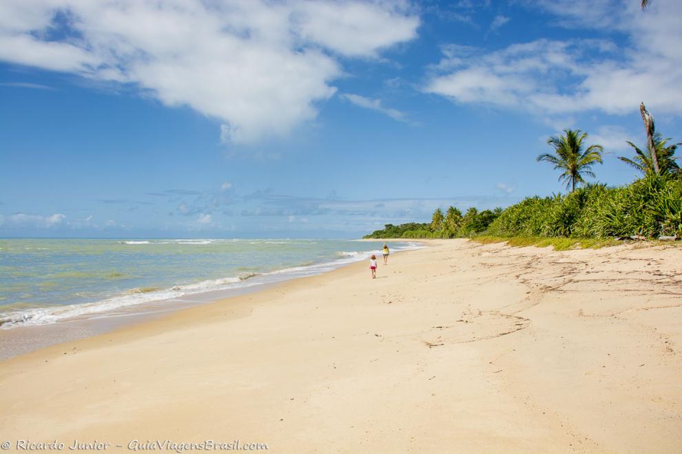 Imagem de mãe e fliha caminhando na Praia da Itapororoca.